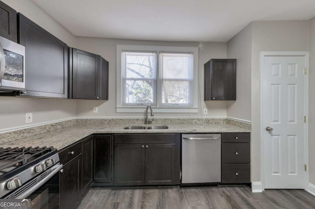 1333 Womack Ave, Atlanta, GA 30344 - kitchen with light stone counters, sink, hardwood / wood-style floors, and appliances with stainless steel finishes