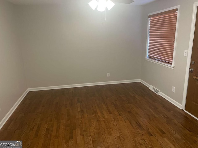 empty room featuring dark wood-type flooring and ceiling fan