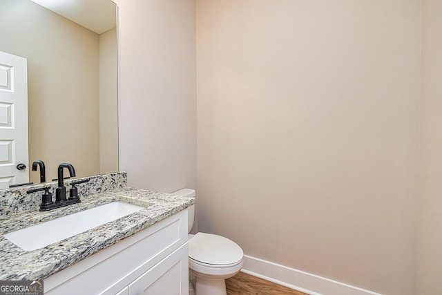 bathroom featuring vanity, hardwood / wood-style floors, and toilet