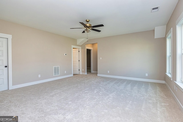 spare room featuring light colored carpet and ceiling fan