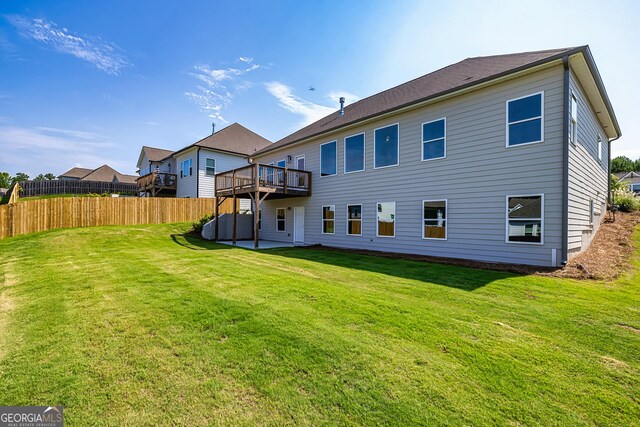 back of property featuring a wooden deck and a lawn