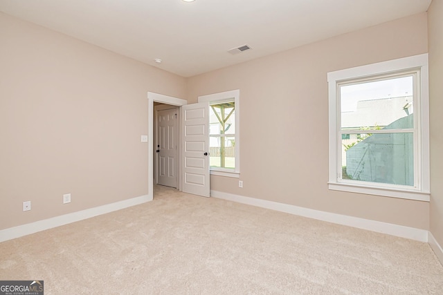 empty room with plenty of natural light and light carpet