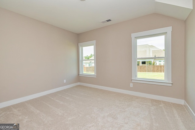 carpeted empty room featuring lofted ceiling and a healthy amount of sunlight