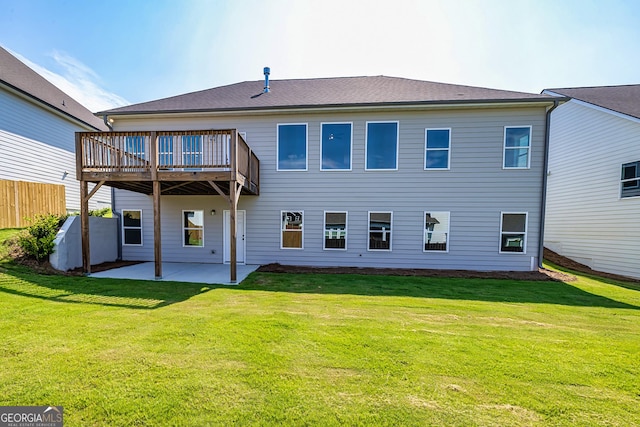 back of property with a wooden deck, a patio area, and a lawn