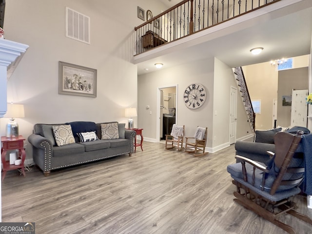 living room featuring hardwood / wood-style flooring and a towering ceiling