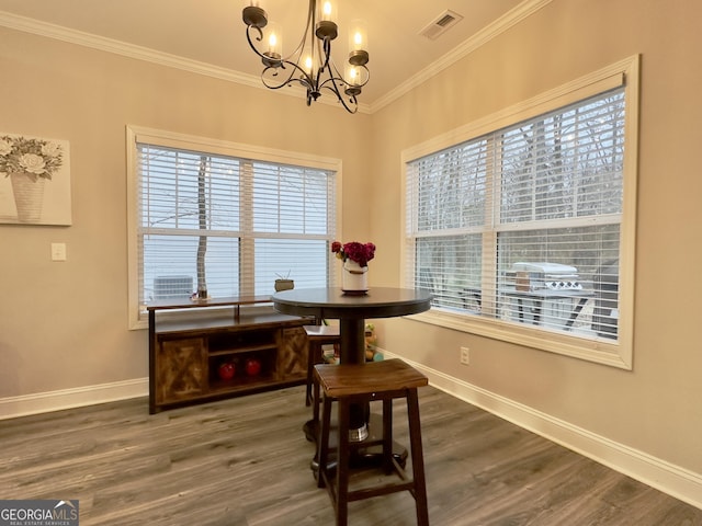 dining space with crown molding, dark hardwood / wood-style floors, and a notable chandelier