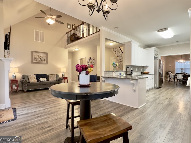 dining room featuring crown molding, light hardwood / wood-style flooring, and ceiling fan with notable chandelier