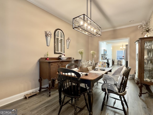 dining area with crown molding, dark hardwood / wood-style flooring, and a notable chandelier