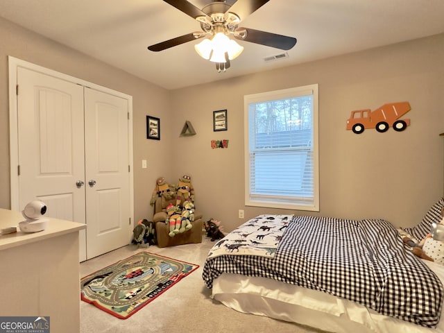 bedroom featuring ceiling fan, light carpet, and a closet