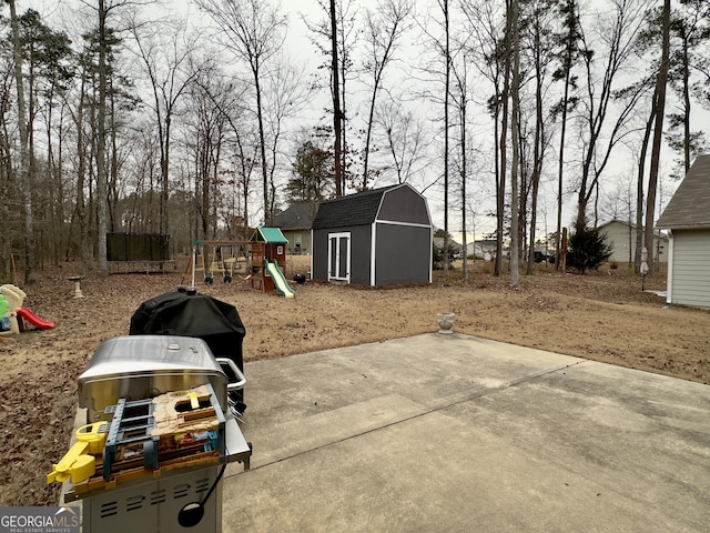 view of patio / terrace with a playground and a storage unit