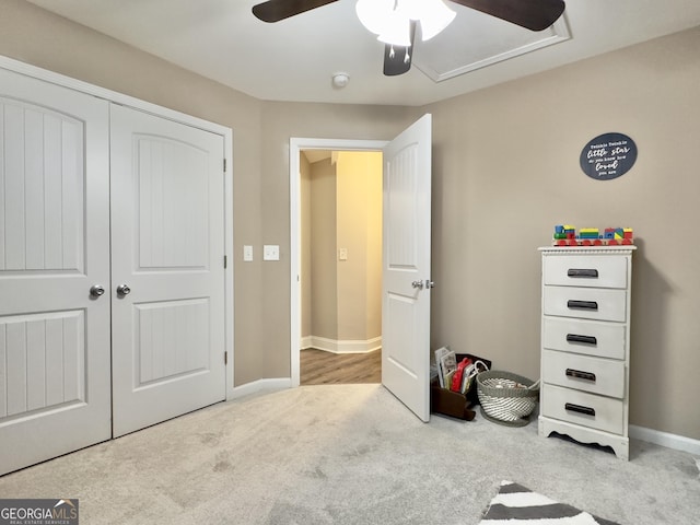 bedroom with ceiling fan, light colored carpet, and a closet