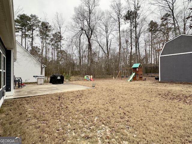 view of yard with a playground, a patio, and a storage shed