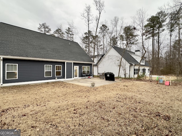 back of house featuring a patio and a lawn