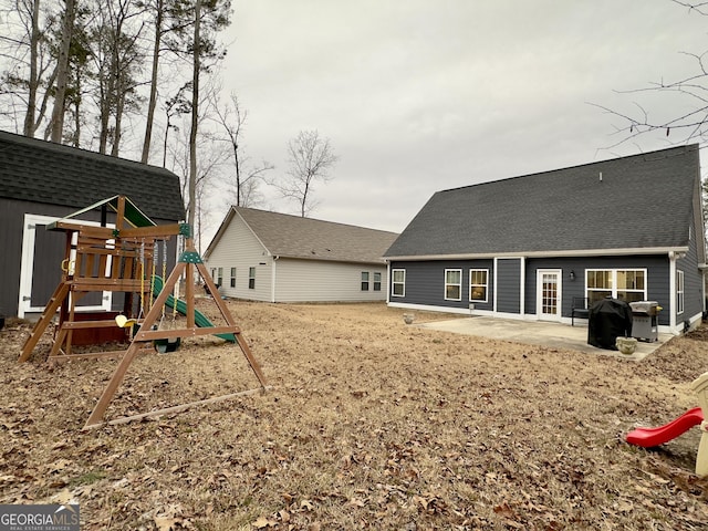 rear view of property with a playground and a patio area