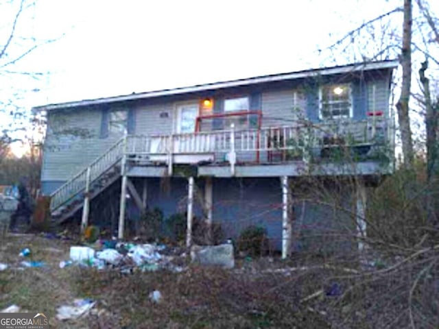 rear view of property featuring a wooden deck