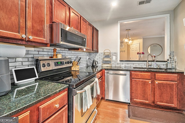 kitchen featuring stainless steel appliances, tasteful backsplash, sink, and light hardwood / wood-style floors