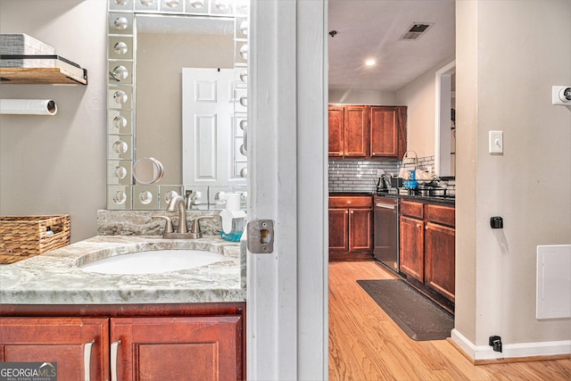 bathroom featuring vanity, hardwood / wood-style floors, and decorative backsplash