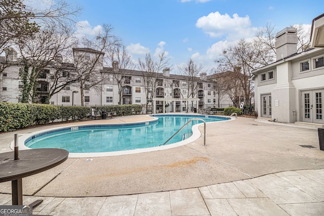 view of swimming pool featuring french doors and a patio