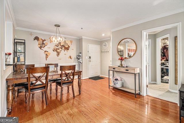 dining room with an inviting chandelier, crown molding, and hardwood / wood-style flooring