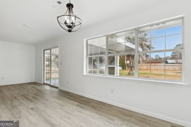 unfurnished dining area featuring a chandelier and hardwood / wood-style floors