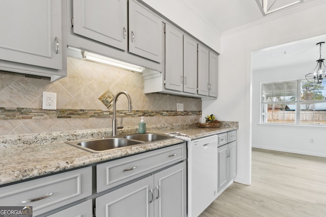 kitchen with dishwasher, sink, backsplash, ornamental molding, and light wood-type flooring