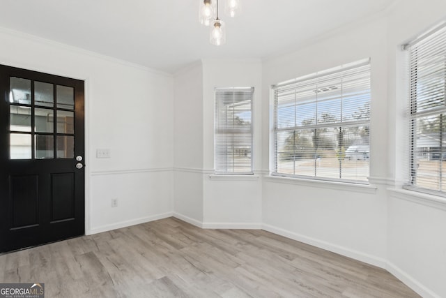 interior space featuring crown molding and light hardwood / wood-style flooring