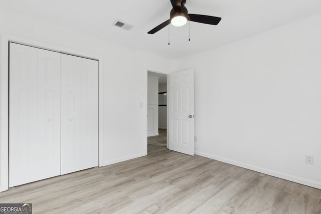 unfurnished bedroom with light hardwood / wood-style floors, a closet, and ceiling fan