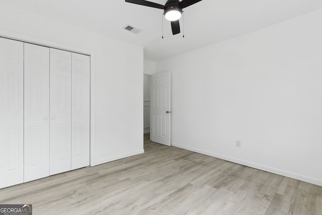 unfurnished bedroom with light hardwood / wood-style floors, a closet, and ceiling fan