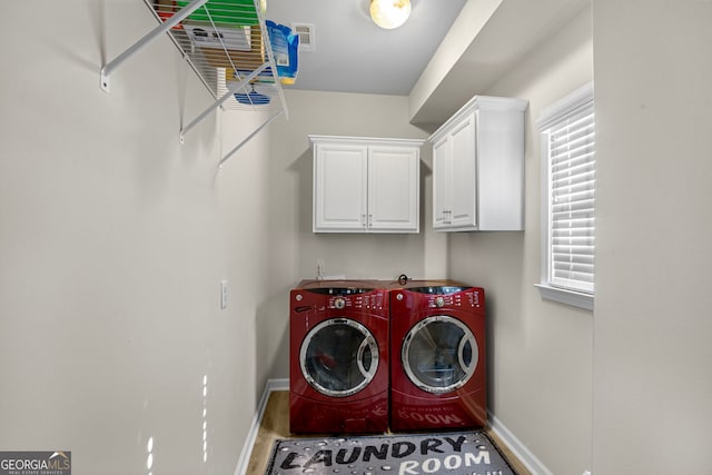 washroom featuring washer and clothes dryer and cabinets