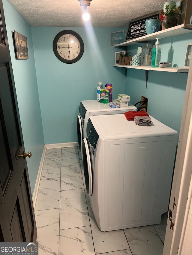 laundry room with washing machine and dryer and a textured ceiling