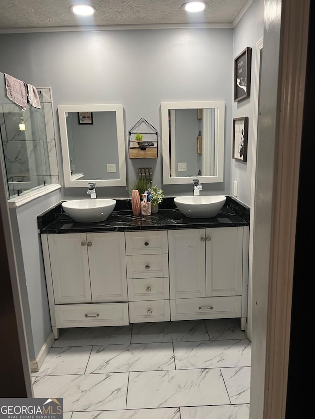 bathroom with vanity, ornamental molding, and a textured ceiling