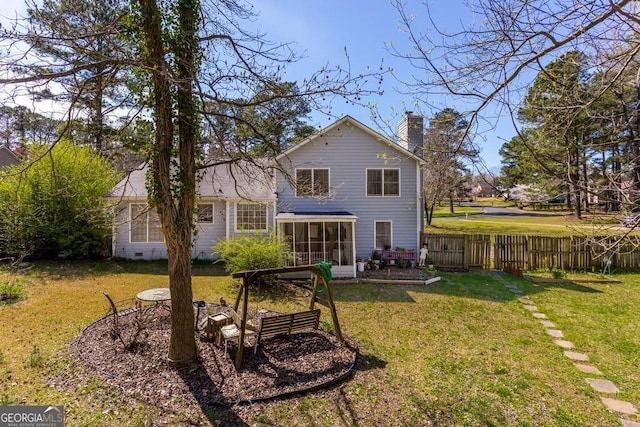 rear view of house with a sunroom and a lawn