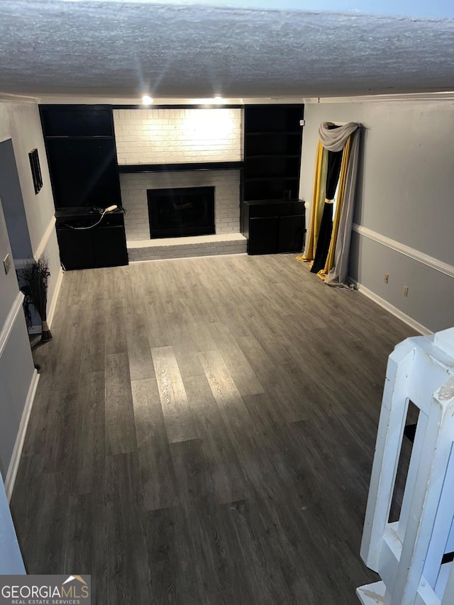 basement with dark hardwood / wood-style flooring and a fireplace