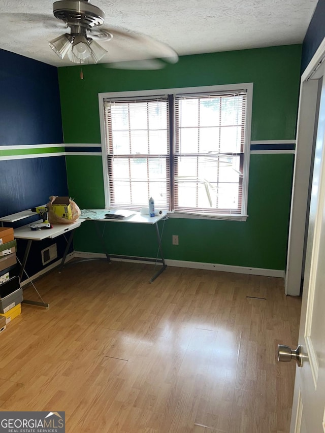 unfurnished bedroom featuring multiple windows, a textured ceiling, and ceiling fan