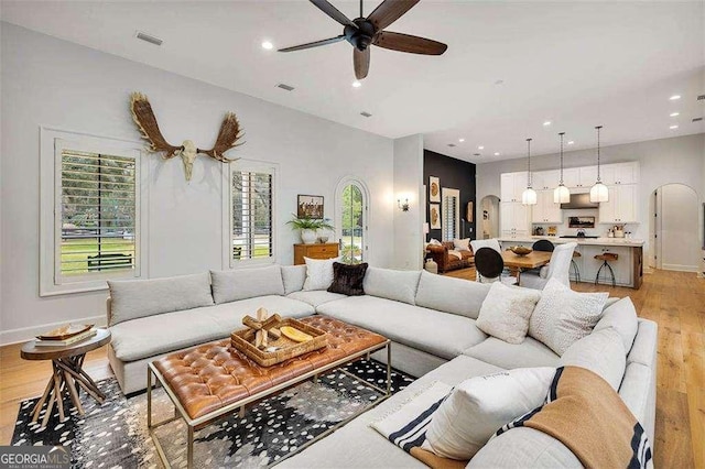 living room with ceiling fan and light hardwood / wood-style floors