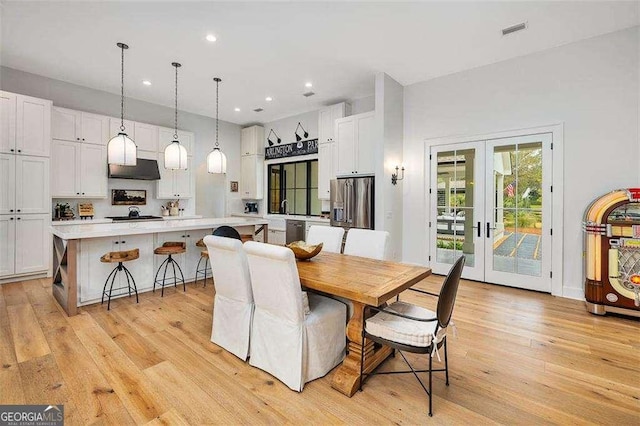 dining space with french doors and light wood-type flooring