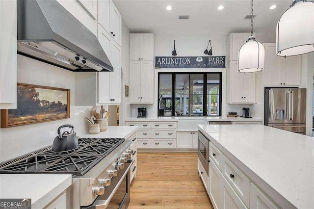 kitchen with light hardwood / wood-style flooring, hanging light fixtures, high end appliances, ventilation hood, and white cabinets