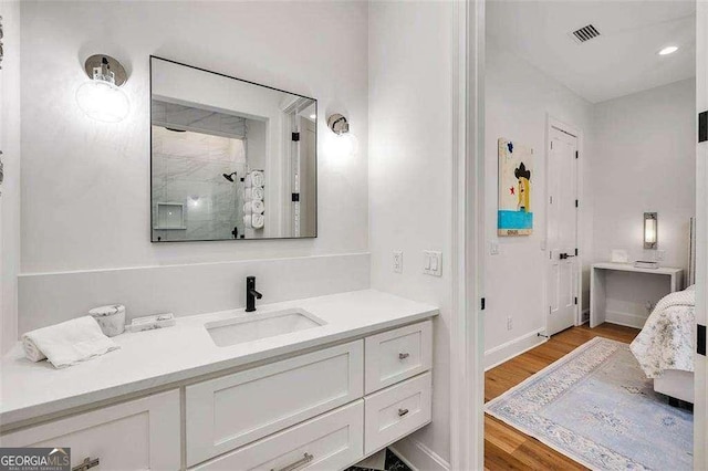 bathroom featuring wood-type flooring, vanity, and a shower