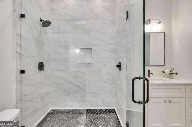 bathroom with vanity, toilet, and a shower with shower door