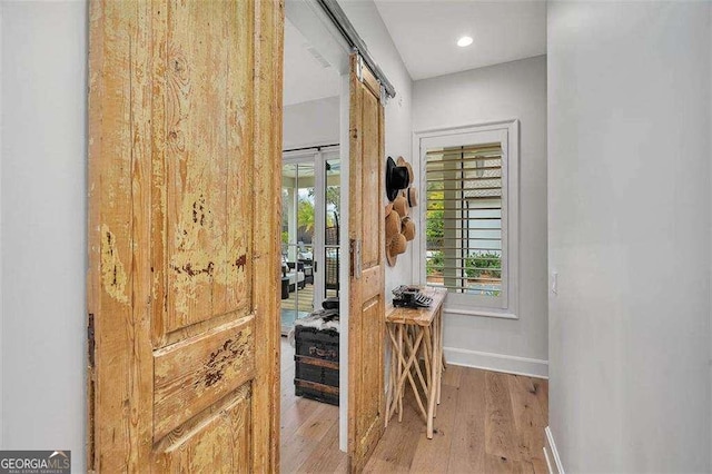 entryway featuring a barn door and light hardwood / wood-style floors