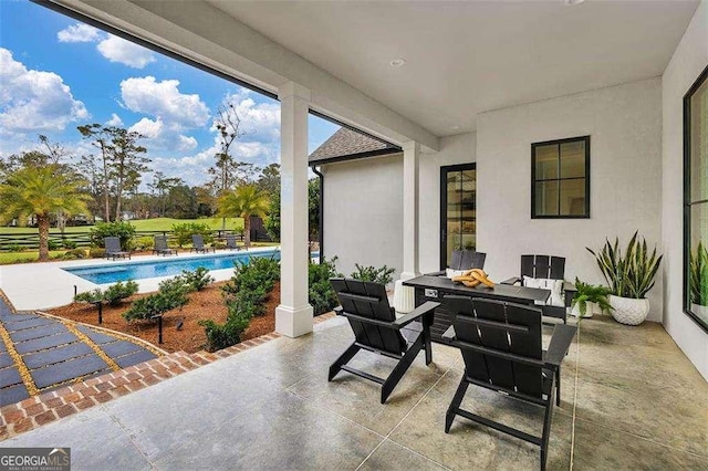 view of patio with a fenced in pool and a fire pit