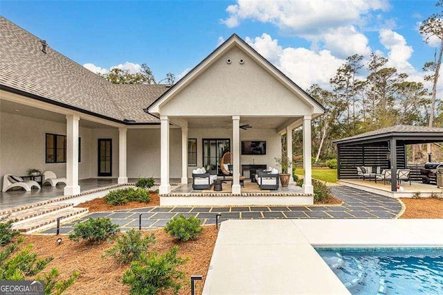 rear view of house with a gazebo, an outdoor hangout area, ceiling fan, and a patio