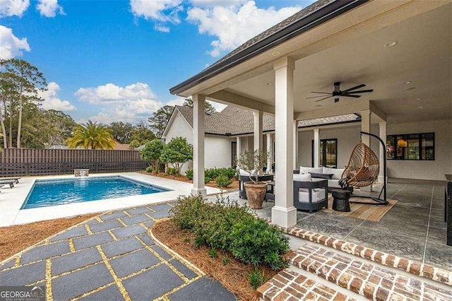 view of pool with outdoor lounge area, ceiling fan, and a patio area