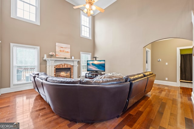 living room featuring hardwood / wood-style flooring, a fireplace, and a towering ceiling