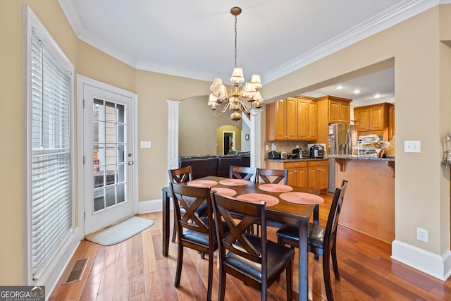 dining area featuring an inviting chandelier, hardwood / wood-style floors, and a wealth of natural light