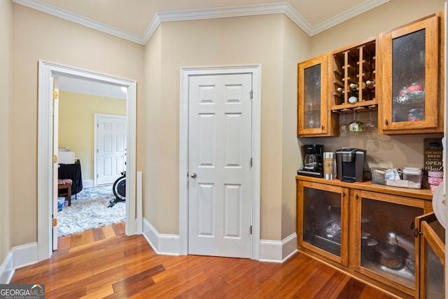 bar with crown molding and hardwood / wood-style floors