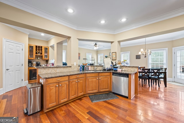 kitchen featuring hardwood / wood-style floors, stainless steel dishwasher, and stone counters