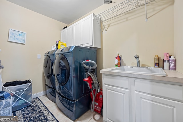 laundry area with cabinets, sink, washer and dryer, and light tile patterned floors