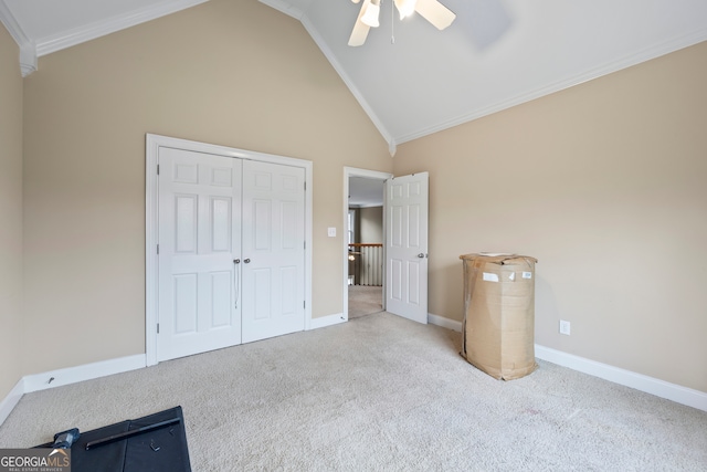 unfurnished bedroom featuring high vaulted ceiling, ornamental molding, light colored carpet, ceiling fan, and a closet