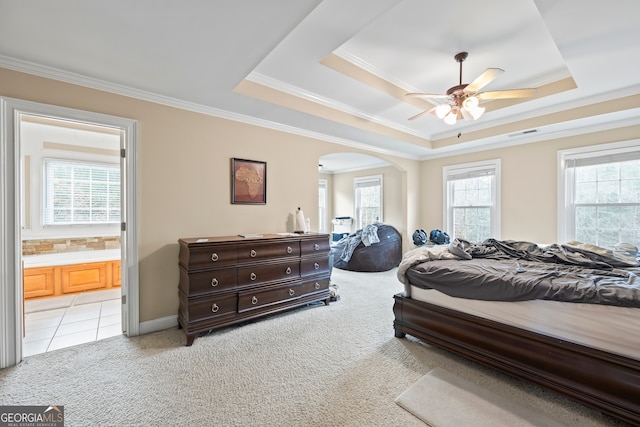 bedroom with light carpet, connected bathroom, crown molding, and a raised ceiling